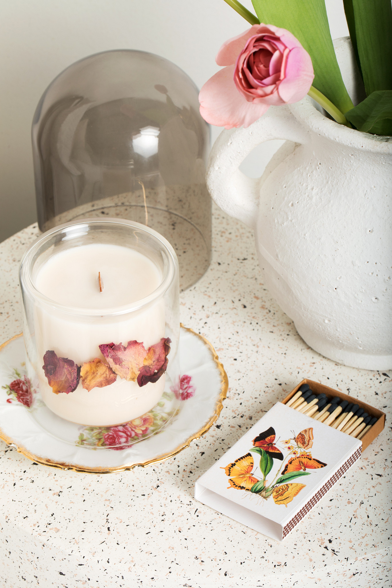 an antique china plate and artisanal cloche with signature rose candle and artisanal vintage matches